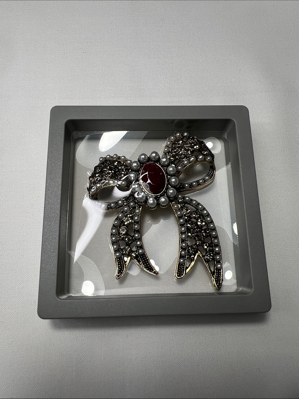 Vintage-Inspired Silver Bow Brooch with Red Cabochon Center